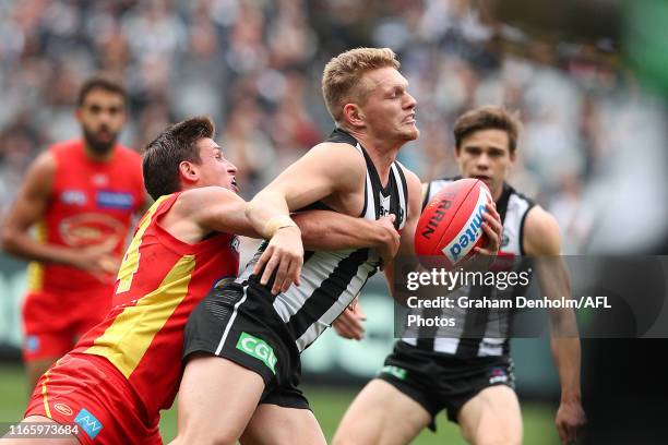 Adam Treloar of the Magpies is tackled during the round 20 AFL match between the Collingwood Magpies and the Gold Coast Suns at Melbourne Cricket...