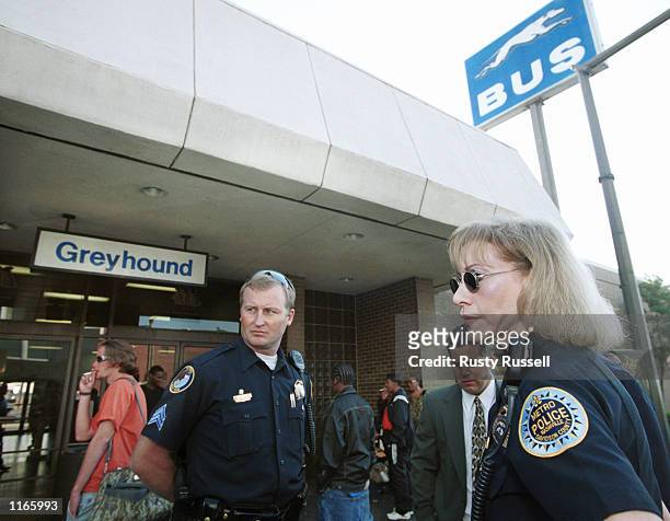 Nashville police officers Lukas Merithew and Nancy Fielder stand guard at a Greyhound bus terminal as passengers wait for service to resume October...