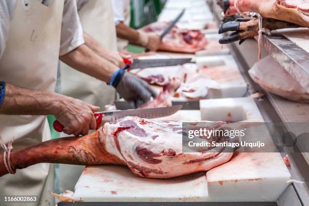 workers preparing jabugo hams - schlachthof stock-fotos und bilder