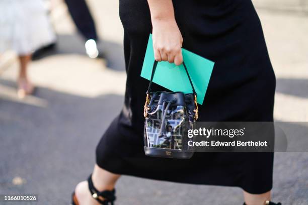 Guest wears a black skirt, a black Fendi bucket bag, outside Miu Miu Club 2020, on June 29, 2019 in Paris, France.