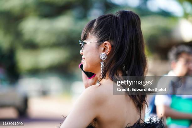 Leaf Greener wears sunglasses, earrings, outside Miu Miu Club 2020, on June 29, 2019 in Paris, France.