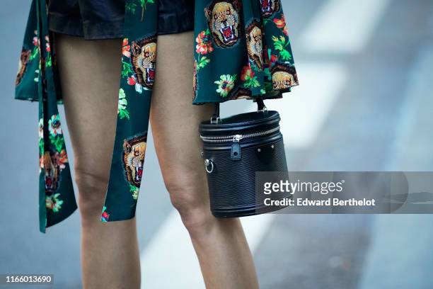 Guest wears an animal and floral print jacket, a black bucket bag, outside the "Scandal A Paris" : Jean-Paul Gaultier's New Fragance Launch Dinner...
