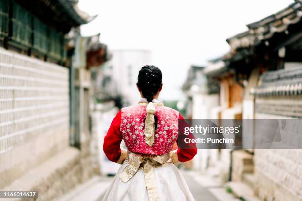 asian woman dressed hanbok pose of standing in bukchon hanok village in seoul, south korea - korea tradition stock pictures, royalty-free photos & images