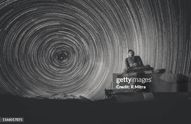 star-trails from the himalayas with the buddha statue! - buddha stock pictures, royalty-free photos & images