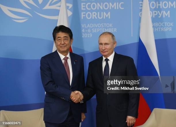 Russian President Vladimir Putin greets Japanese Prime Minister Shinzo Abe during their bilateral meeting at the Russky Island on September 5, 2019...