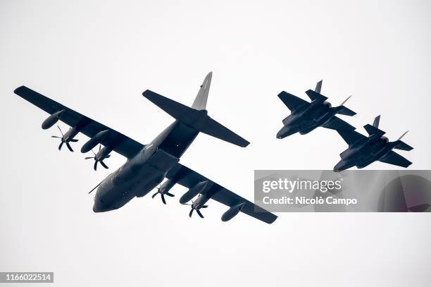 Lockheed Martin C-130J Super Hercules and two Lockheed Martin F-35 Lightning II fly during a military aeronautical training exercise. The Lockheed...