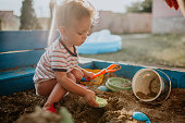 Child plays with his single mother in the sandbox
