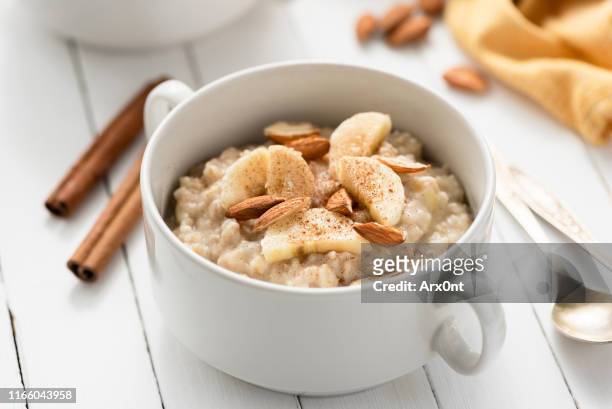 oatmeal porridge with almonds, banana and cinnamon - porridge stock pictures, royalty-free photos & images