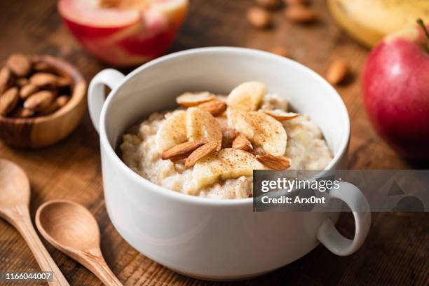 banana cinnamon oatmeal porridge bowl - apple white background stock-fotos und bilder