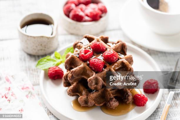 chocolate belgian waffles with syrup and raspberries - stroopwafel stockfoto's en -beelden
