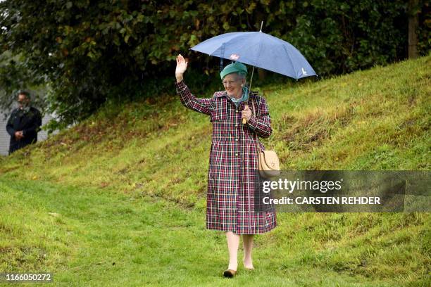 Queen Margrethe II of Denmark waves to wellwishers as she walks on the grounds of the former Danish Danevirke fortification in Dannewerk, northern...