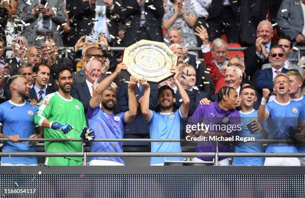 David Silva and Sergio Aguero of Manchester City lift the FA Community Shield following their team's victory in the FA Community Shield match between...