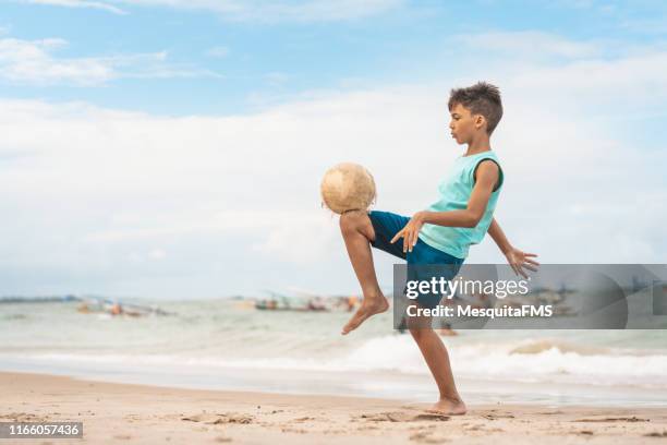 jongen spelen strandvoetbal - football boot stockfoto's en -beelden
