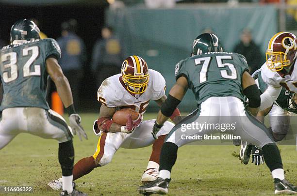 Washington Redskins running back Clinton Portis looks to slip between two Philadelphia Eagles defenders on Sunday, January 1, 2006 at Lincoln...