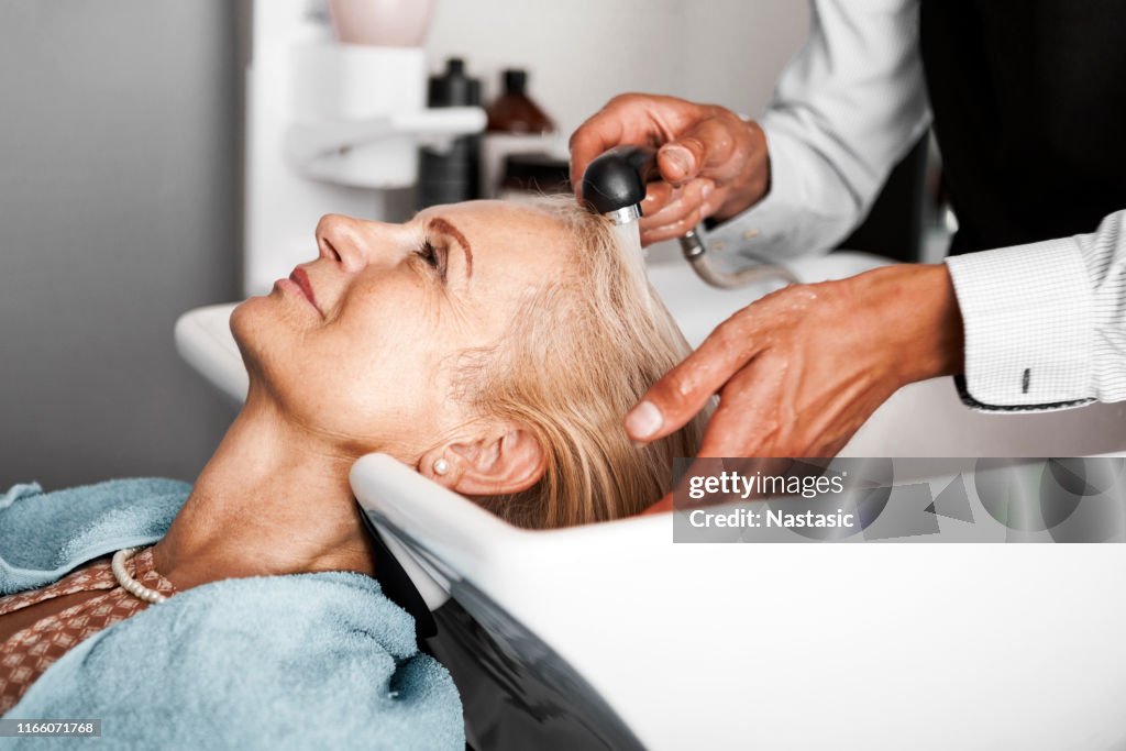 Haar-Stylist waschen reife Frau Haar