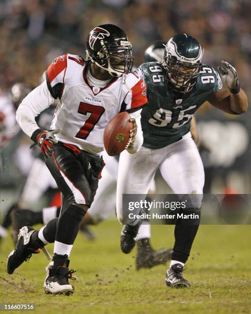 Michael Vick scrambles out of the pocket as Eagles defensive end Jerome McDougle pursues during the game between the Atlanta Falcons and the...