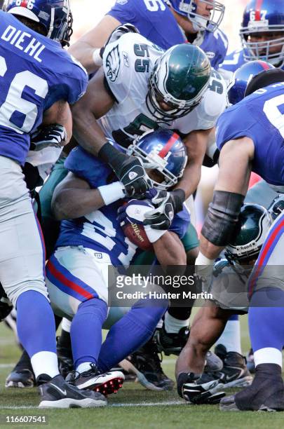 Eagles linebacker Dhani Jones stops Giants running back Tiki Barber during first quarter at Giants Stadium, East Rutherford, New Jersey, Nov. 20,...