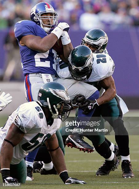 New York Giants running back Tiki Barber is stopped by Philadelphia Eagles safety Brian Dawkins at The Meadowlands in East Rutherford, New Jersey on...