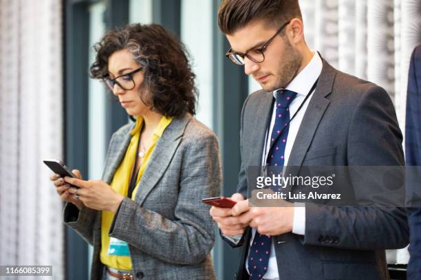 business people using mobile phones in break at convention center - kick off call stock pictures, royalty-free photos & images