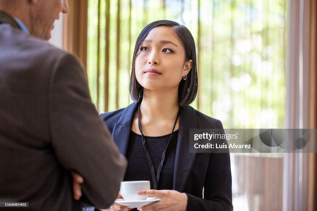 Business professional discussing at break in seminar