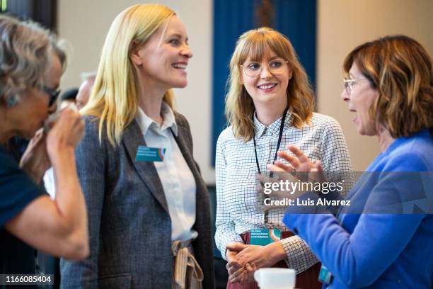 businesswomen discussing during coffee break in seminar - equipment launch party foto e immagini stock