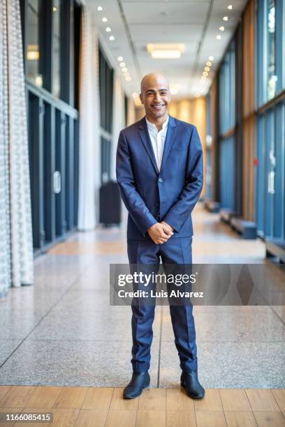 smiling businessman in hotel corridor - executive board portrait session stock pictures, royalty-free photos & images