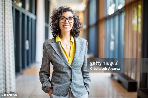smiling female entrepreneur outside auditorium - professional occupation stockfoto's en -beelden