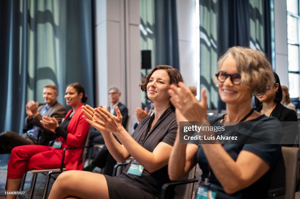 Business professionals applauding during conference