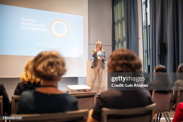 female speaker giving presentation in seminar - business conference auditorium stockfoto's en -beelden