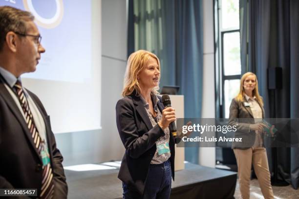 businesswoman giving a speech in conference - business conference auditorium stockfoto's en -beelden