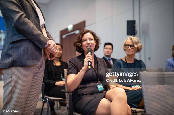 businesswoman asking questions during a seminar - emcee stock pictures, royalty-free photos & images