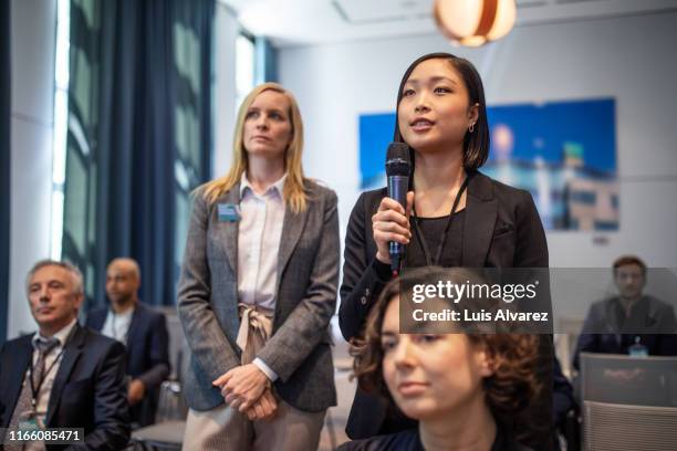 female executive asking some questions during a launch event - questions and answers stock pictures, royalty-free photos & images