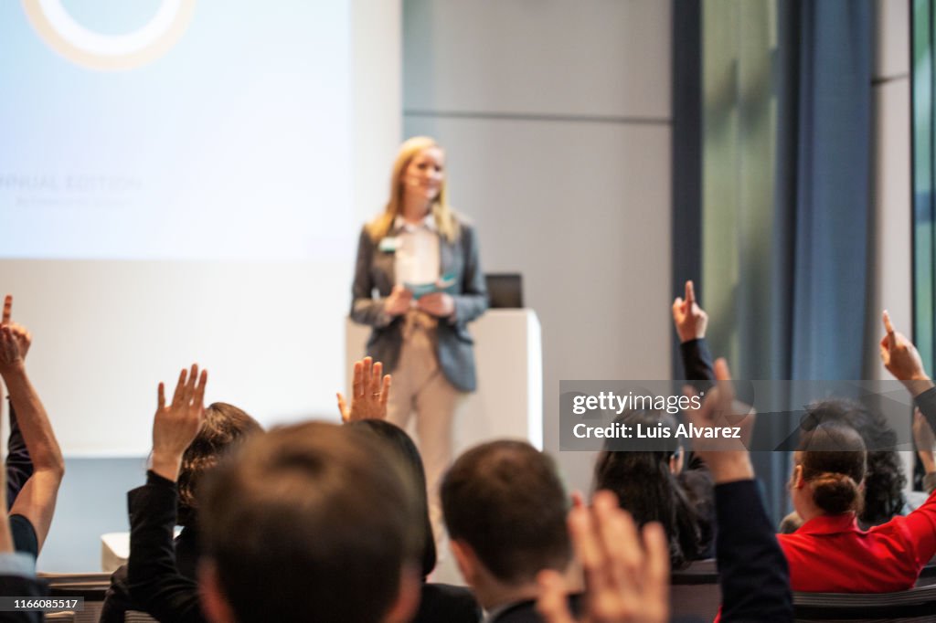 People asking queries during a seminar