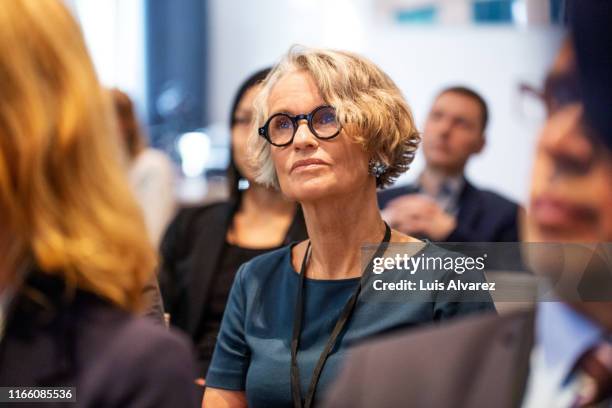 senior businesswoman attending seminar - business conference auditorium stockfoto's en -beelden