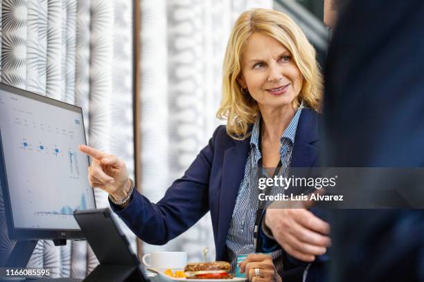 corporate professionals discussing over computer in auditorium - theatre program stock pictures, royalty-free photos & images