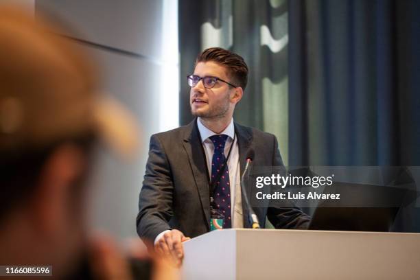 businessman giving speech during seminar - business conference auditorium stockfoto's en -beelden
