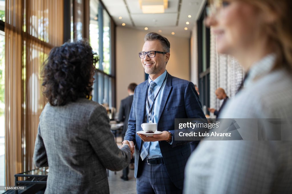 Entrepreneurs greeting each other in break at seminar