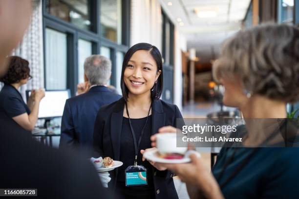 businesswomen discussing during coffee break in hotel - business women networking stock pictures, royalty-free photos & images
