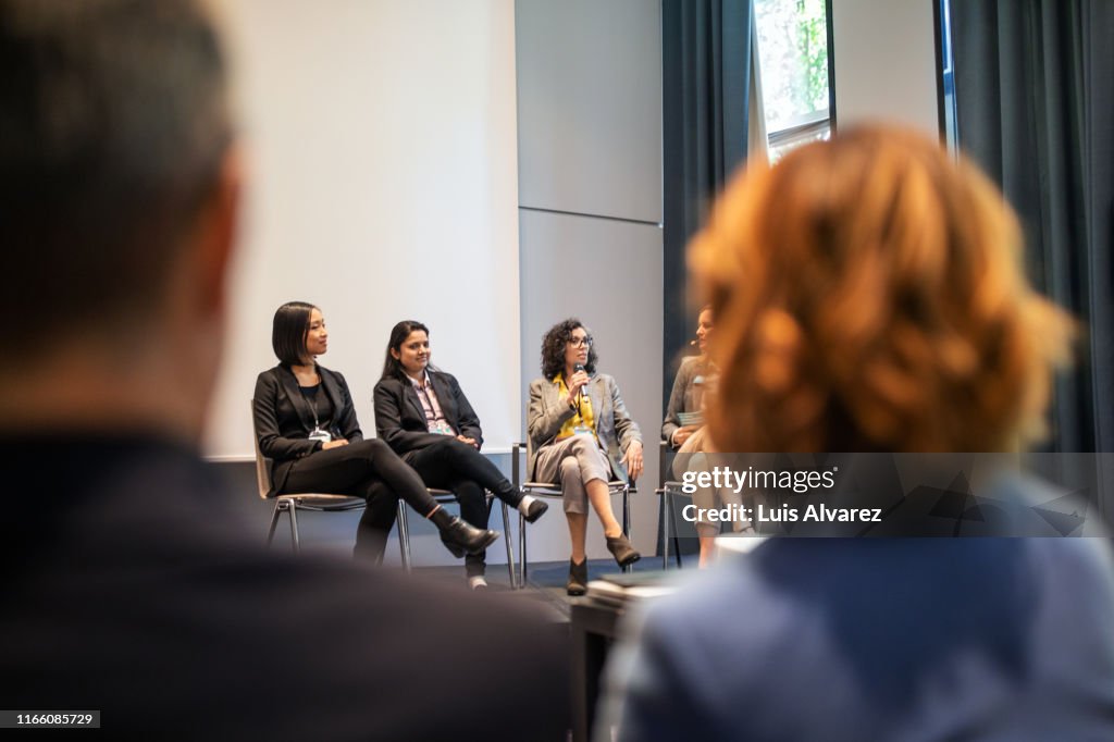 Female expert panel discussing during conference