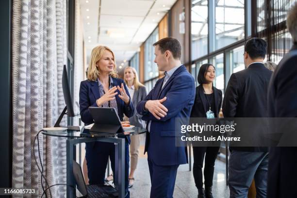 business professionals at launch event - mature business woman digital tablet corporate professional stockfoto's en -beelden