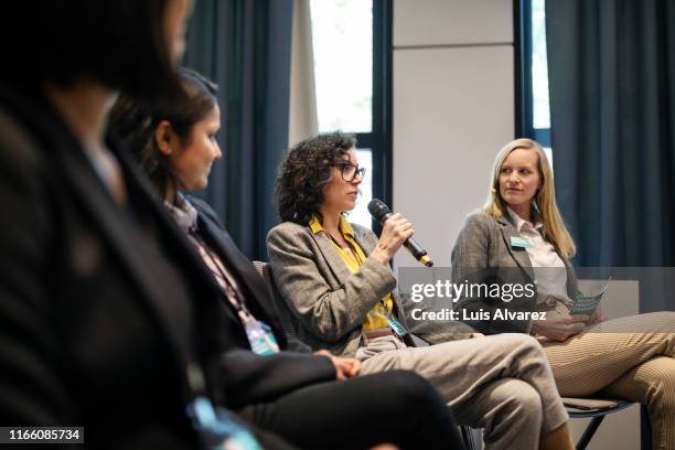 businesswoman sharing her ideas to colleagues in a seminar - panel discussion stock pictures, royalty-free photos & images