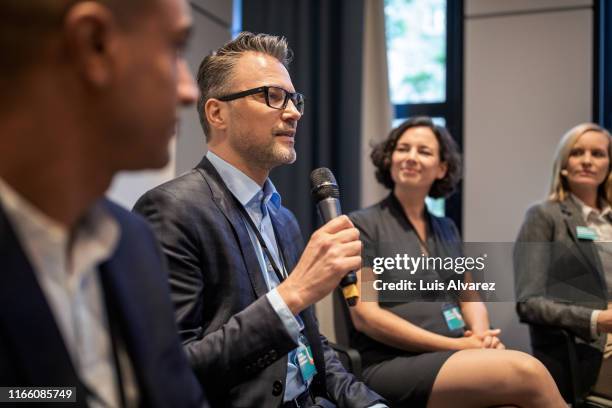 mature businessman talking in a seminar - business conference auditorium stockfoto's en -beelden