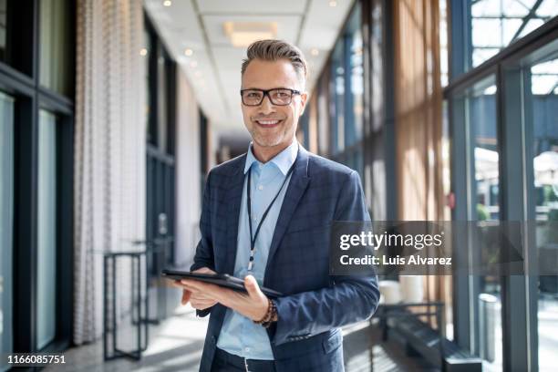 entrepreneur standing in hotel corridor - executive board portrait session stock pictures, royalty-free photos & images