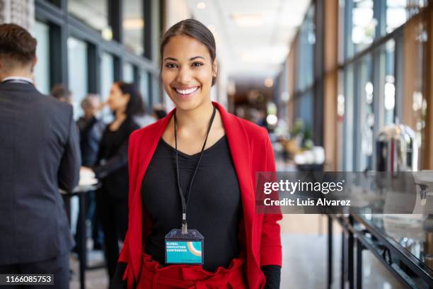 confident businesswoman standing in convention center - id card stock-fotos und bilder