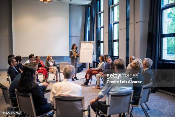 businesswoman giving presentation in convention center - panel discussion stock pictures, royalty-free photos & images