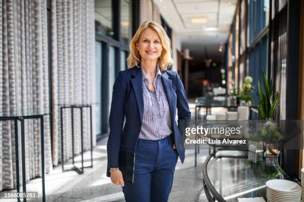 portrait of beautiful businesswoman in auditorium corridor - blue blazer stock pictures, royalty-free photos & images