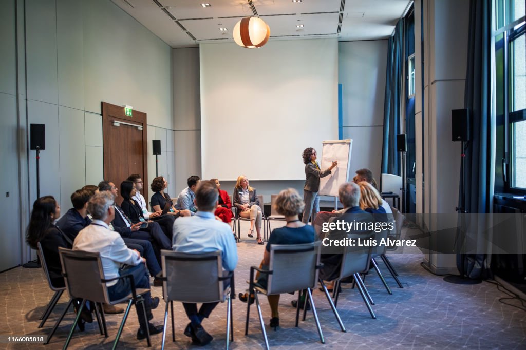 Businesswoman explaining strategy over a flip chart