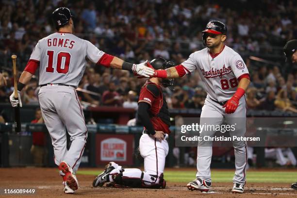 Gerardo Parra of the Washington Nationals high fives Yan Gomes after Parra hit a two-run home run against the Arizona Diamondbacks during second...