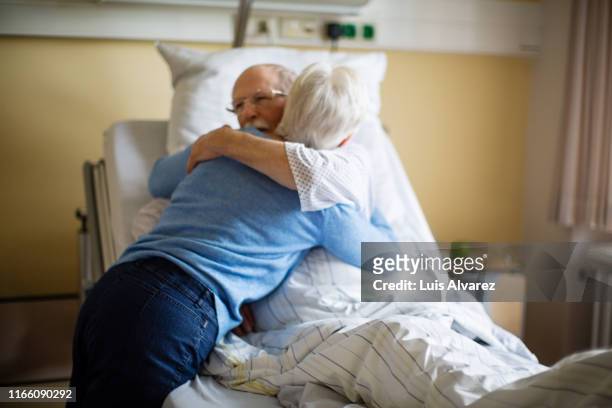senior woman visiting her husband in hospital - visit stock-fotos und bilder