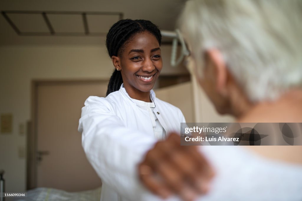 Doctor comforting her senior patient in the hospital room